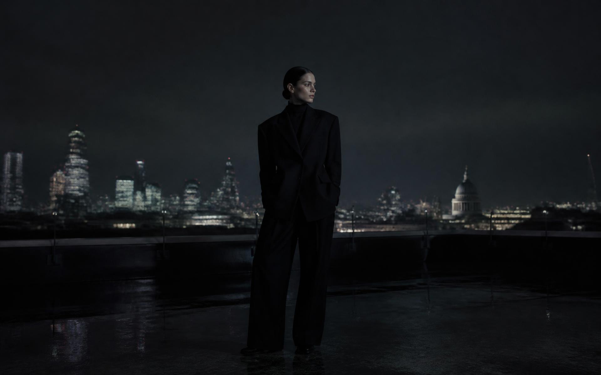 Model in black tailoring on a European rooftop at midnight